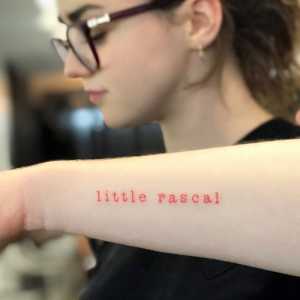 Maisie Williams has a tattoo on her left forearm reading “little rascal” in red ink.