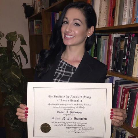 Amie holding her doctorate degree.