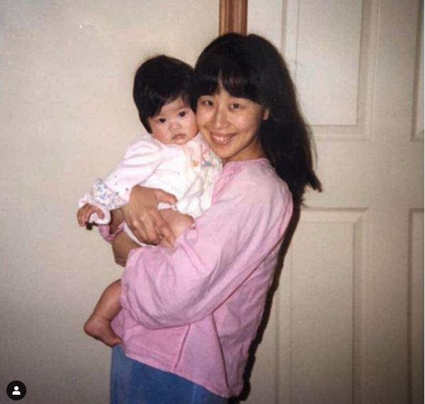 Childhood photo of Melody Peng in her mother's arm.