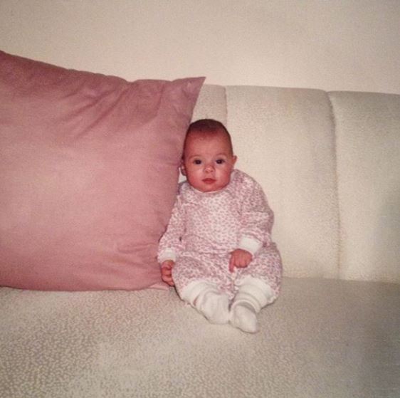 Childhood photo of Jon Hein sitting on the bed.