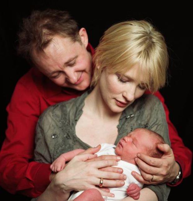 Photo of newly born, Dashiell John Upton in his mother's arm beside his father.