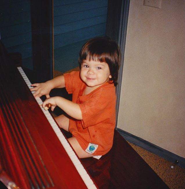 Childhood photo of Wolfgang Van Halen playing the piano.