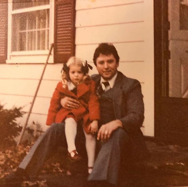 Childhood photo of Tara Reid sitting on her father's thigh.