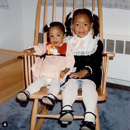 Erinn Westbrook and her cousin sister sitting on the chair.