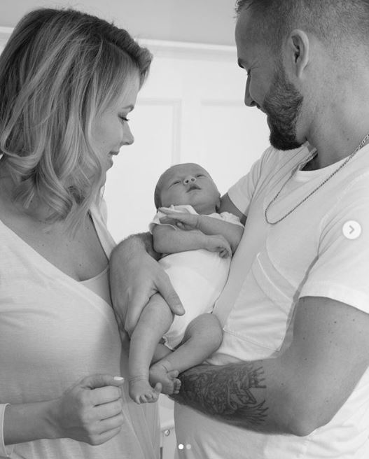 Sherry Holmes and Damon Bennett holding their daughter, Cali Kay Holmes Steed on their arms.