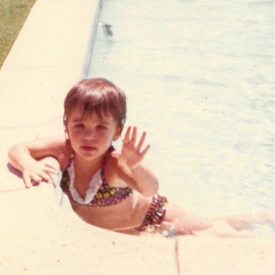 Childhood photo of Bethenny Frankel while swimming on the pool.