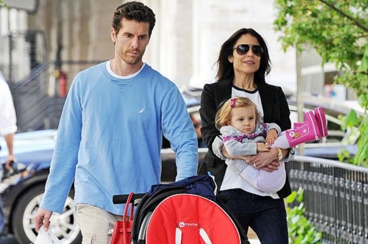 Bethenny Frankel carrying her daughter, Bryn in her arm aside with her husband, Jason Hoppy.