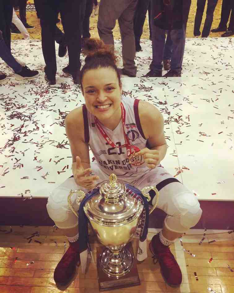 Photo of Kayle McBride is wearing a gold medal along with the Championship Trophy.