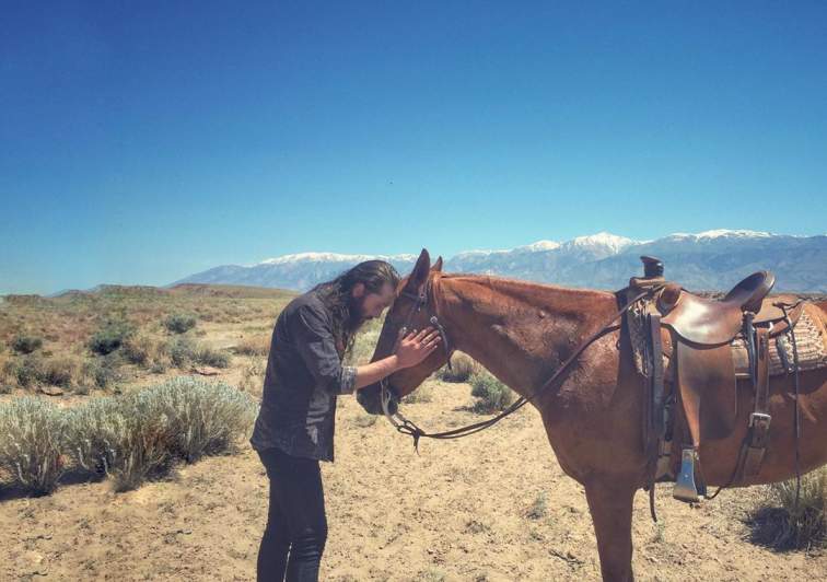 Avi Kaplan is showing his love for a horse in Bishop, California.