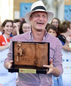 Woody Harrelson holding one of his Award
