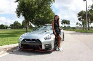 Naomi posing in front of her Bently.