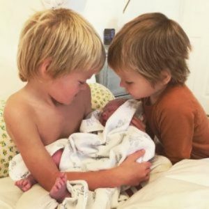 Sasha blue Pownall (left) holding her newly born brother.