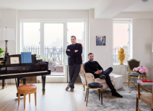 Isaac Mizrahi (standing up) and his husband (in a sofa) in their NYC apartment