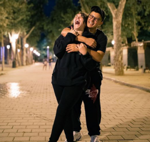 Jesaaelys Ayala Gonzalez laughing with her boyfriend Charles Olmo who is hugging her from behind.